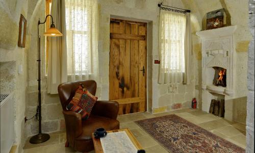 a living room with a chair and a fireplace at Seki Cave Suites in Goreme