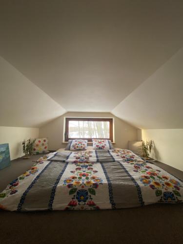 a large bed in a room with a window at Siedlisko Odpoczynkowo in Nowosiółki