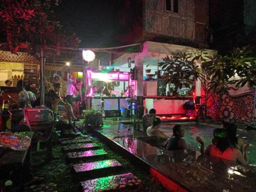 a group of people sitting at a bar at night at Arjuna Garden Homestay in Yogyakarta