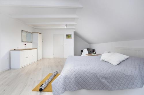 a white bedroom with a bed and a kitchen at Krab in Rewal