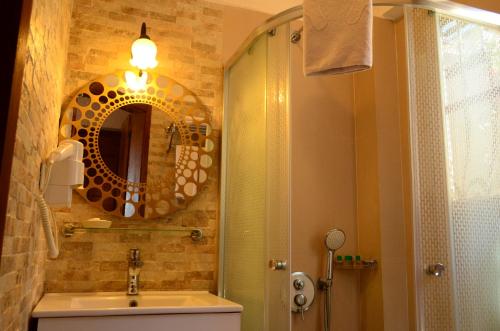 a bathroom with a shower and a sink and a mirror at Ada Bacchus Hotel in Bozcaada