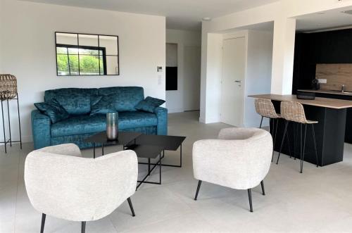 - un salon avec un canapé bleu et des chaises dans l'établissement Résidence Storia d'Estate, à LʼÎle-Rousse