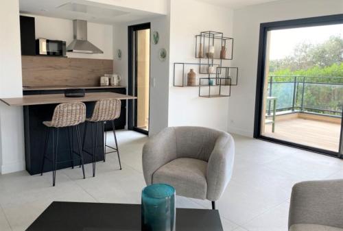 a living room with a chair and a table at Résidence Storia d'Estate in LʼÎle-Rousse