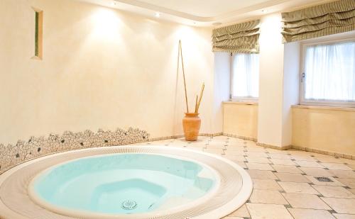 ein großes Bad mit einer großen Badewanne in einem Zimmer in der Unterkunft Hotel Mondschein in Sterzing
