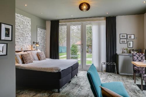 a bedroom with a bed and a large window at Boutique Hotel 't Vosje in Haarlem