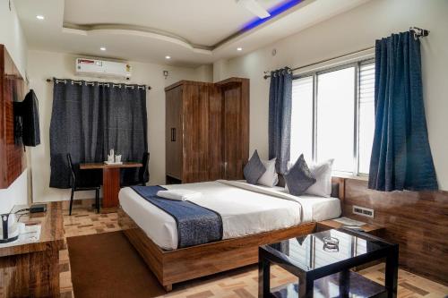 una camera con letto e scrivania di Hotel Heritage a Kuch Bihār