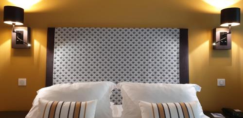 a bedroom with a bed with two lights on the wall at Hotel Argi Eder in Aïnhoa