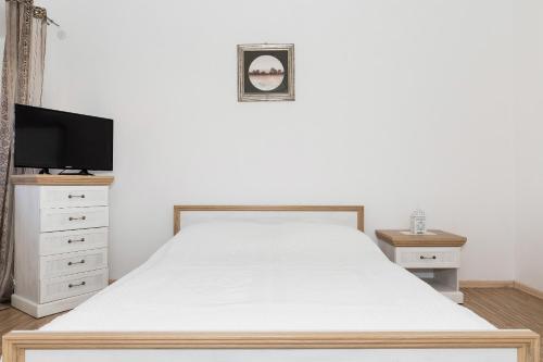 a bedroom with a white bed and a tv at Krab in Rewal