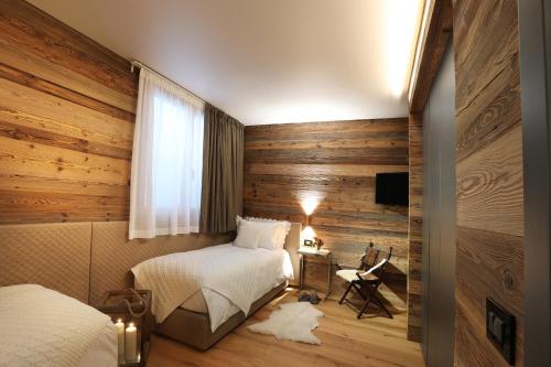 een slaapkamer met 2 bedden, een bureau en een televisie bij Petit Chalet Blanc Cervinia in Breuil-Cervinia