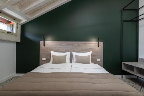a bedroom with a large bed with a green wall at Oysters & Bubbles Gastro Hotel. Rynok square in Lviv