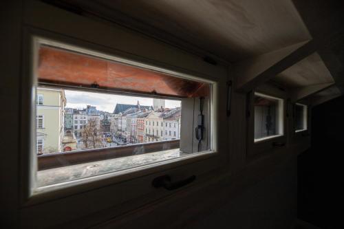 a window on a train looking out at a city at Oysters & Bubbles Gastro Hotel. Rynok square in Lviv