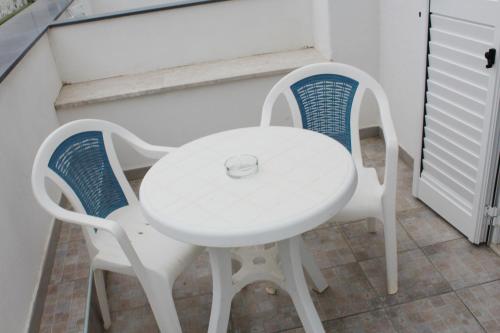 two chairs and a white table and a white table and chairs at Hotel Castiglione in Ischia