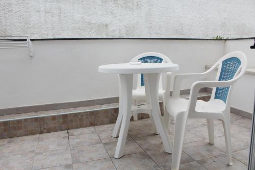 a white table and two chairs in front of a wall at Hotel Castiglione in Ischia