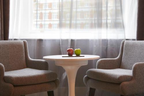 two chairs and a table with an apple on it at Malmaison London in London