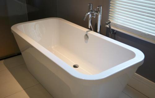 a white bath tub in a bathroom with a window at Malmaison London in London