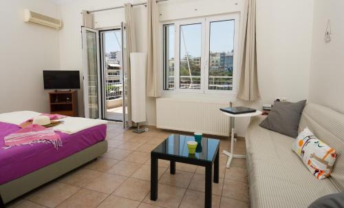 una sala de estar con una cama y un sofá en Straight to the Lake View Apartments, en Agios Nikolaos