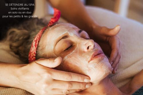 a woman getting a head massage at a spa at Hôtel L'Arboisie in Megève