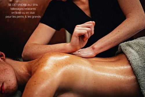 a woman getting a back massage from a man at Hôtel L'Arboisie in Megève