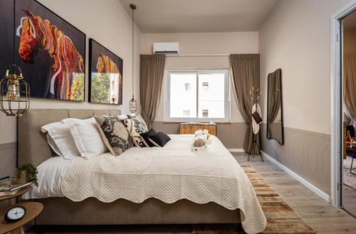 a bedroom with a large bed with a dog sitting on it at Ben Yehuda, 3 Lovely Flats in the same building in Jerusalem