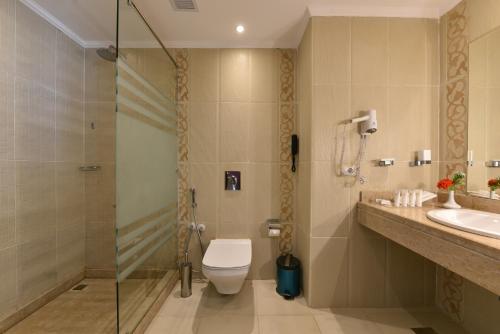 a bathroom with a shower and a toilet and a sink at Tolip North Coast Hotel in El Alamein