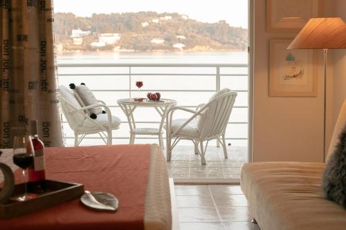 een woonkamer met een tafel en stoelen op een balkon bij Casa Blue Marine, Philian Collection in Skiathos-stad