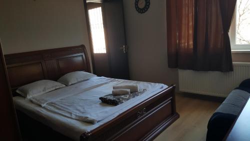 a bed with a wooden frame with a book on it at Guesthouse different in Tbilisi City