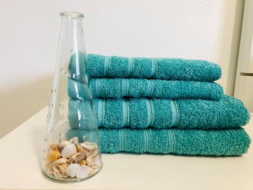 a group of green towels with shells in a vase at Apartamento Llimera Altea in Altea