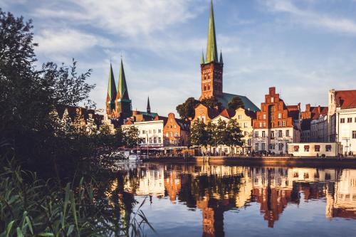 a view of a city with a river and buildings at Hotel Die Reederin in Lübeck