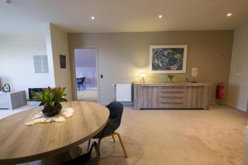 a living room with a table and a desk at SHAMBALLA logies nieuw en zeer verzorgd appartement met voortuin en terras in Deinze