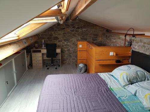a bedroom with a bed and a desk in a attic at Duplex Swimming Cats in Saint-Hilaire-sur-Helpe