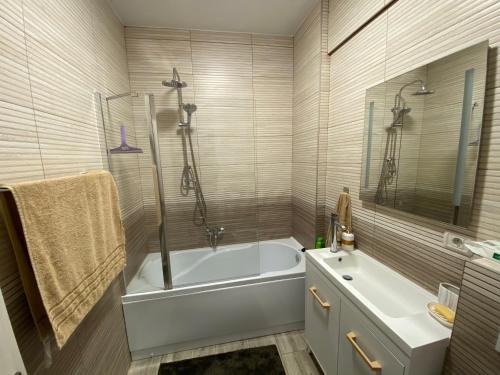a white bathroom with a tub and a sink at Top View Apartment in Suceava