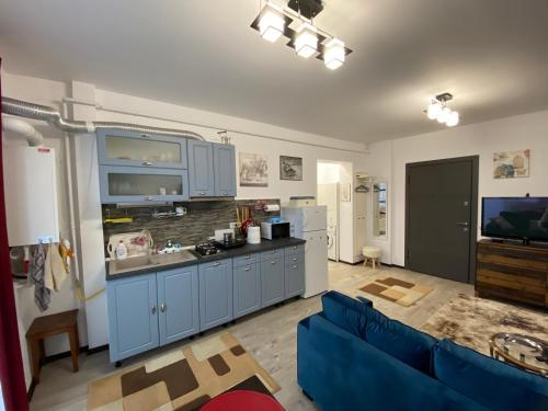 a kitchen with blue cabinets and a blue couch at Top View Apartment in Suceava