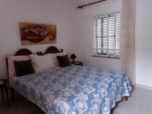 a bedroom with a bed with a blue and white comforter at SOL & MAR in Lagos