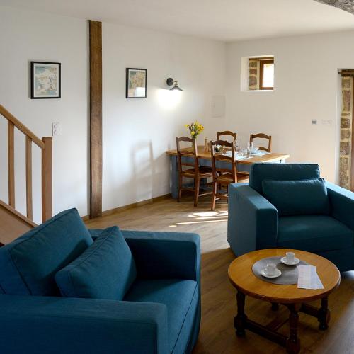 a living room with two blue couches and a table at La Martinière in Saint-Aubin-Fosse-Louvain