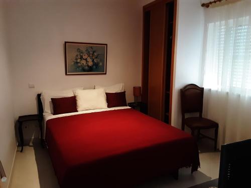 a red and white bed in a room with a window at SOL & MAR in Lagos