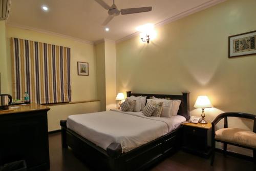a bedroom with a bed and two lamps and a window at La Maison by Dia Hotels and Homes in Panaji