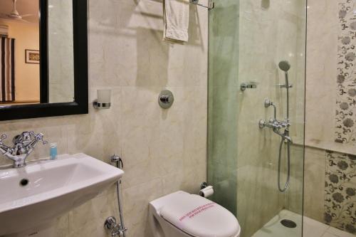 een badkamer met een douche, een wastafel en een toilet bij amã Stays & Trails La Maison Fontainhas in Panaji