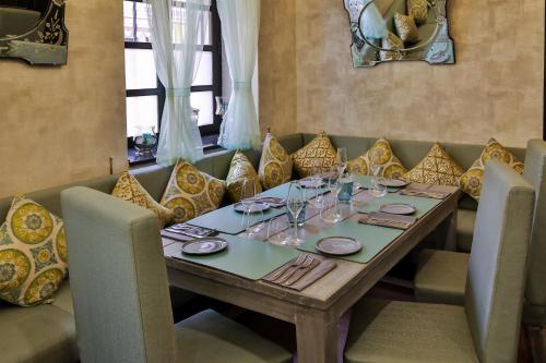 a wooden table with chairs and plates and wine glasses at La Maison by Dia Hotels and Homes in Panaji
