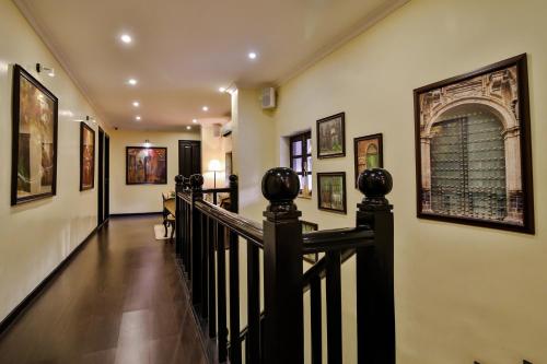 a hallway with a staircase with paintings on the walls at La Maison by Dia Hotels and Homes in Panaji