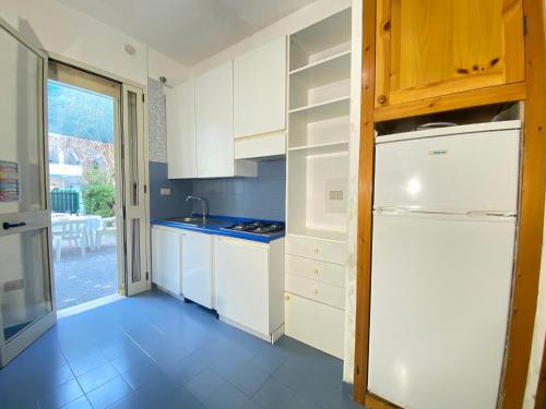 eine Küche mit weißen Schränken und einem weißen Kühlschrank in der Unterkunft BAIA VERDE BEVERLY Gallipoli in Baia Verde