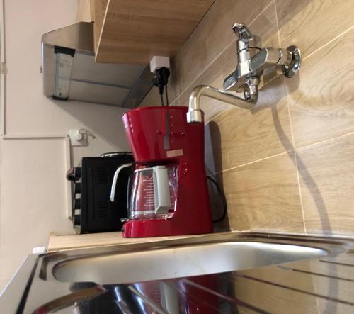 una cafetera roja sobre un fregadero de cocina en Lemon Tree Inn, en Markopoulo