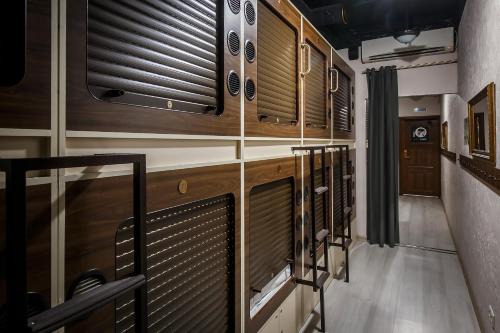 a hallway with wooden cabinets and blinds in a room at Capsule Hotel InterQUBE Tretyakovskaya in Moscow