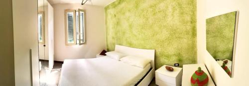 una camera con un letto bianco e una parete verde di Sun Home a Torre Pali
