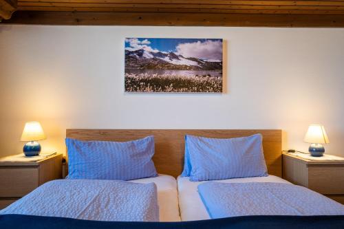 a bedroom with two beds with blue pillows at Naturpension Mühlhof in Neukirchen am Großvenediger