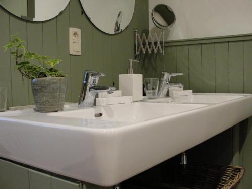 a white sink in a bathroom with a mirror at B&B Hedera in Herne