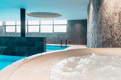a pool with a hot tub in a building at Van der Valk Hotel Mons Congres & Spa in Mons