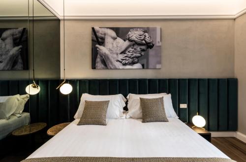 a bedroom with a large white bed with two pillows at Growel Exclusive Suites San Pietro in Rome