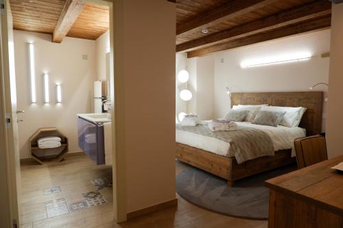 a bedroom with a bed and a bathroom with a sink at Maison Bertin in Etroubles