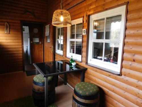 a room with a table and two barrels and a chandelier at Ferienhaus Bussard in Gammelsbach