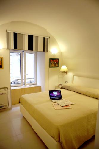 a hotel room with a laptop on a bed at Donna Caterina in Sorrento